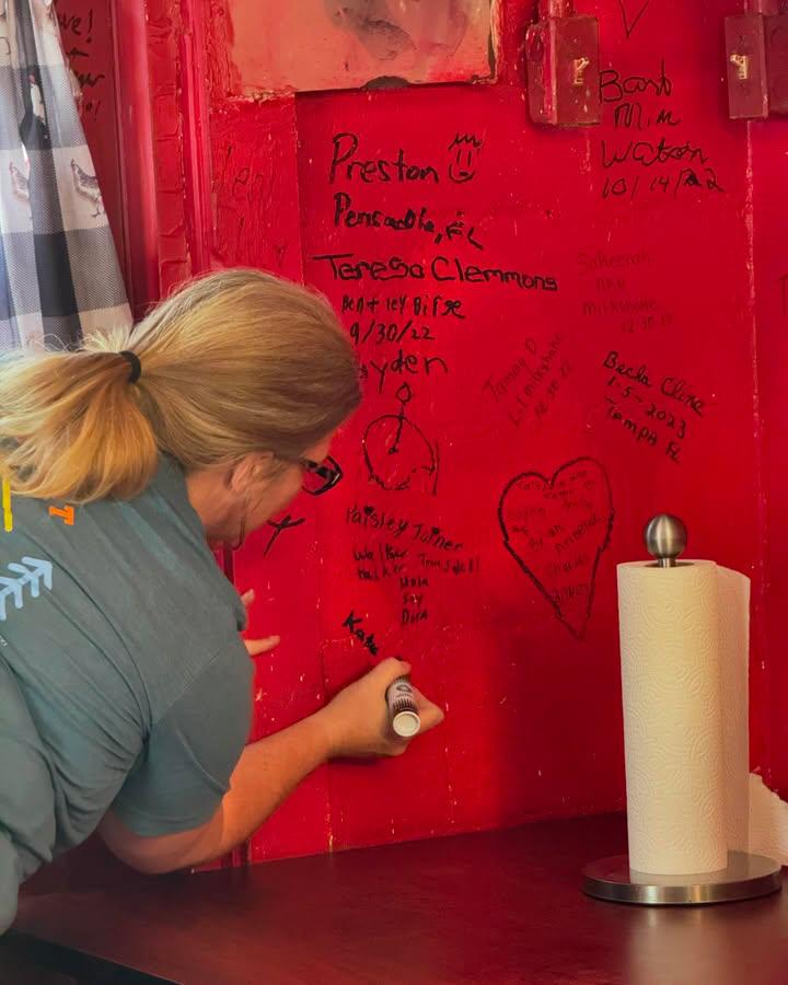This restaurant encourages diners to sign their walls with black marker