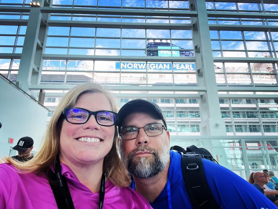 Kate and Steve take a selfie in front of the Norwegian Pearl cruise ship before getting on board for a vacation
